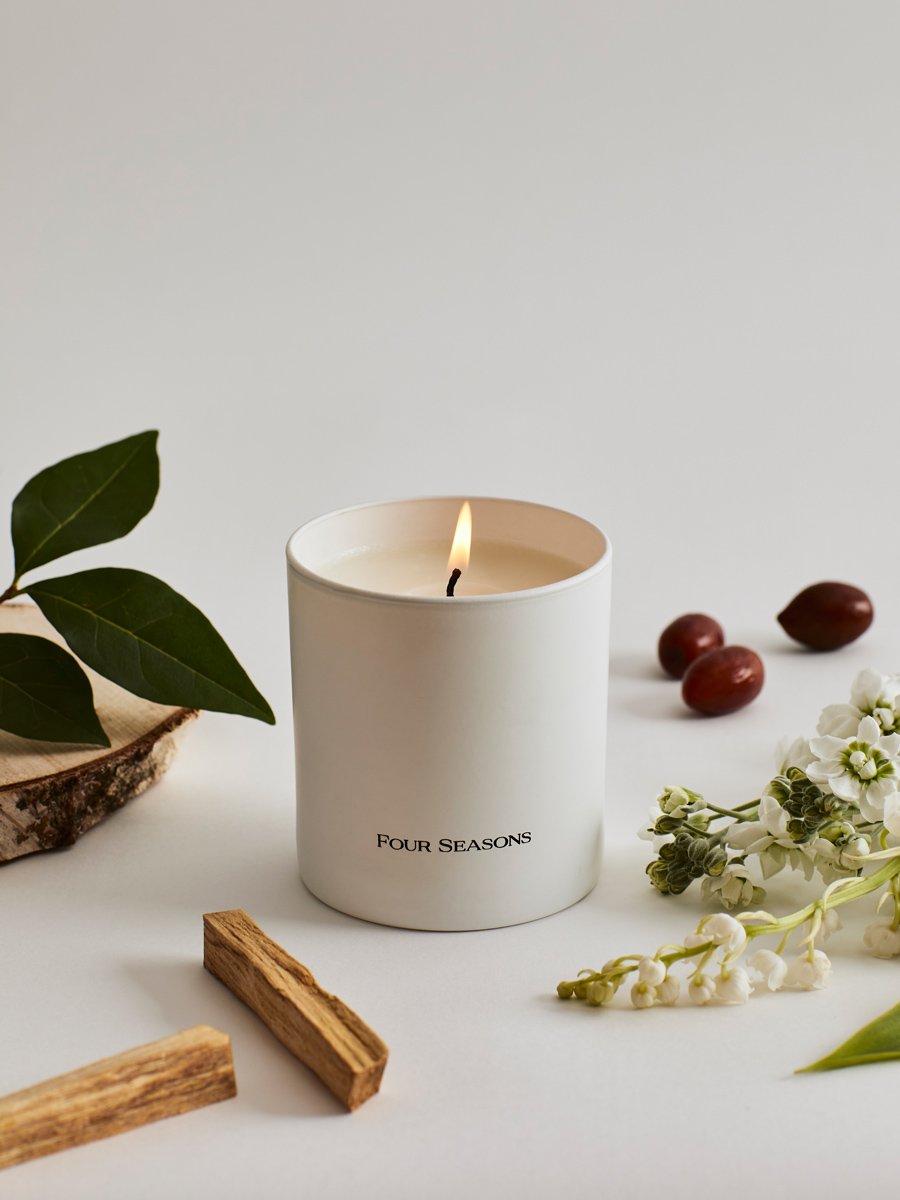 Four Seasons Signature Votive, Enchanted Garden scent, white candle, fresh woods and Palo Santo notes, luxury home accessory